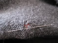 the needle has been placed on top of the gray fabric, and it is broken