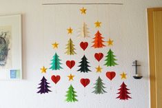 a christmas tree made out of paper hanging on the wall