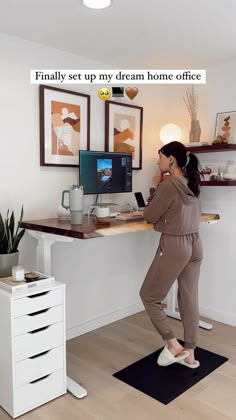 a woman standing in front of a computer desk