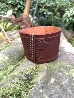 a close up of a leather cuff on a rock