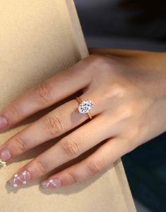 a close up of a person's hand with a diamond ring on her finger