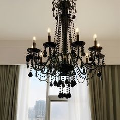 a chandelier hanging from the ceiling in front of a window