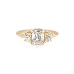 the three stone engagement ring in yellow gold with an oval diamond center and side stones