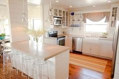 a kitchen with white cabinets and counter tops