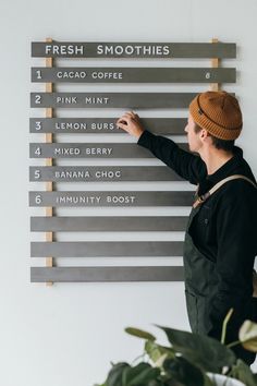 a person standing in front of a sign that says fresh smoothies and cocoa coffee