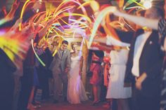 a group of people standing next to each other at a party with streamers in the air