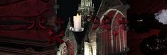 a candle that is sitting in the middle of a building with red and white decorations on it