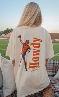 Say HOWDY! from football country in this off-white tee complete with a vintage inspired illustration of a quarterback mid pass! We love the red and yellow colorway of this design. 


Haley is 5'6" and is wearing size medium

Maggie is 5'4" and is wearing an XL for an oversized look


sizing guide: 


fits true to size - size up for an oversized fit

medium measurements: 41" bust and 28.5" length

100% cotton


WE ONLY OFFER STORE CREDIT FOR RETURNS! Feel free to email us at orders@shopriffraf Vintage College Football Shirts, Country T Shirt Designs, Game Day T Shirts, Game Day Shirts Football, College Shirt Ideas, School Shirt Ideas, Track Shirt, Off White Tees, Football Apparel