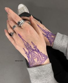 a woman's hand with purple ink on her left wrist and two rings in the middle