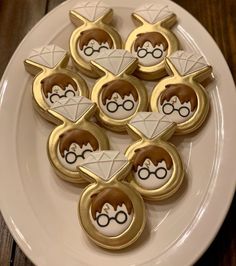 some cookies are on a white plate with gold trim and decorated like harry potters