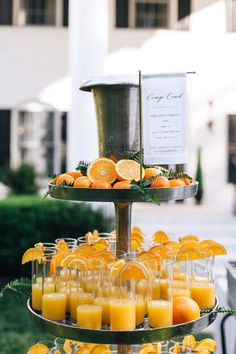 there are many oranges and glasses on the tray with juice in them, as well as an order sign