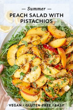 a white bowl filled with peach salad and topped with pesto, lettuce and lemon wedges