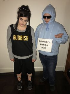 two people dressed up in costumes and one is holding a sign that says rubbish she doesn't even go here