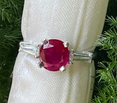 Burmese round ruby and diamond ring in platinum.  This beautiful red Burmese ruby is a round cut mined in Burma and certified by a gemologist with authenticity.  The ruby weighs 2.29cts.  Set on either side of ruby is a tapered baguette weighing together approximately 1/3ct. With clarity and color VS1, F. Size 7.5.  This ring can be sized to fit your finger. Gia Certified Round Cut Ruby Ring Fine Jewelry, Classic Gia Certified Diamond Ring With Lab-created Ruby, Gia Certified Round Cut Ruby Ring, Brilliant Cut Diamond Ruby Ring, Ruby Ring With Brilliant Cut Diamond, Round Brilliant Cut Ruby Ring With Diamonds, Brilliant Cut Ruby Ring With Diamonds, Gia Certified White Gold Ruby Ring, Red Diamond Ring With Brilliant Cut In Platinum