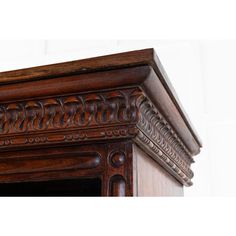 an ornate wooden frame with carved details on the top and bottom part, in dark wood