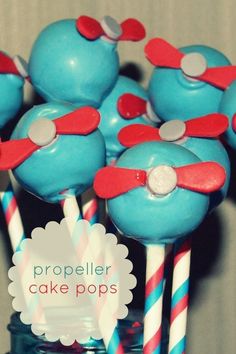 some blue cake pops with red and white striped straws in them on a table