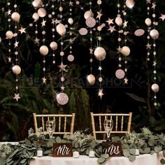 the table is decorated with ornaments and greenery for an elegant wedding reception at night