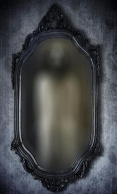 an old fashioned mirror hanging on the wall