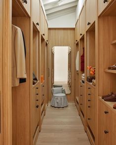 an empty walk - in closet with lots of wooden cabinets