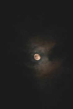 the full moon is seen through the clouds in the dark night sky with only one cloud visible