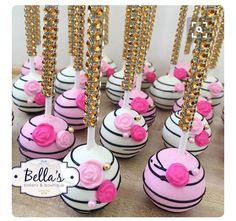 there are many pink and white desserts with gold decorations on top of each one