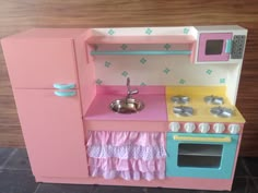 a toy kitchen with pink and blue appliances