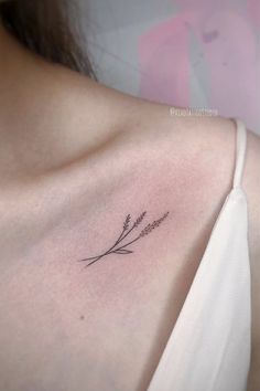 a woman's shoulder with a small flower tattoo on the left side of her chest