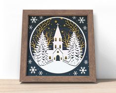 a wooden frame with a christmas scene in the center and snowflakes around it