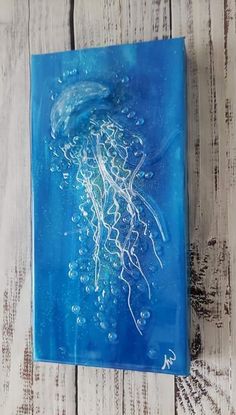 a blue glass tile with an image of a jellyfish on it's side