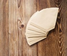 six folded napkins on top of a wooden table