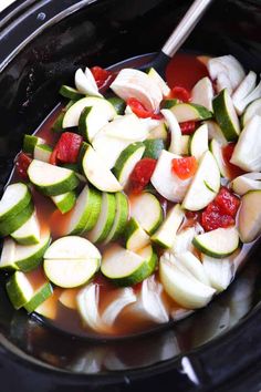 sliced cucumbers and other vegetables in a slow - cooker with spoons