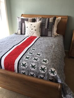 a bed with a blanket and pillows on top of it in a bedroom next to a window