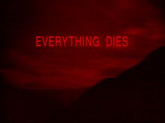 a red neon sign that says everything dies on the side of a mountain at night