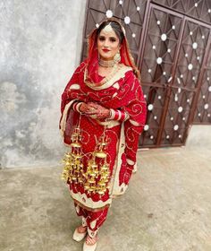 a woman dressed in red and gold poses for the camera