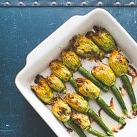 a white dish filled with brussel sprouts on top of a blue table