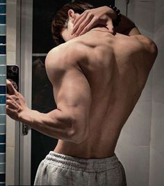 a man taking a selfie in front of a mirror with his back turned to the camera