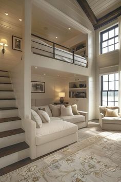 a living room filled with white furniture next to a stair case in front of a window