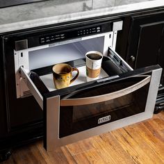 a coffee cup is sitting in an open oven door with its tray on the stove