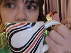 a woman is drinking from a coffee cup