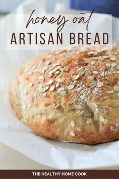 a loaf of artisan bread sitting on top of a piece of wax paper with the words, honey out artisan bread