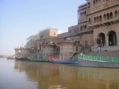 several boats are parked in front of a building on the water's edge,