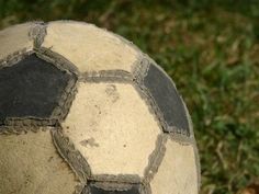 an old soccer ball sitting on the grass