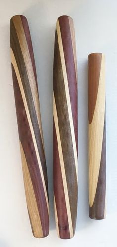 three wooden baseball bats lined up against a white wall