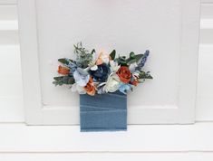 a blue vase filled with flowers on top of a window sill next to a white wall