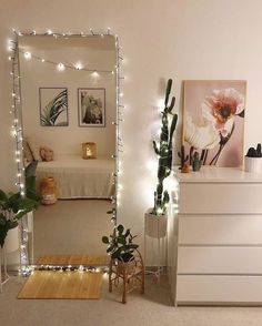 a bedroom with white walls and lights on the wall, along with a mirror that says huge mirror with rice lights