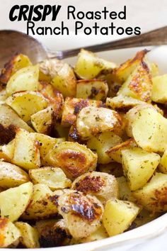 crispy roasted ranch potatoes in a white bowl with a spoon on the side and text overlay