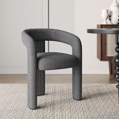 a gray chair sitting on top of a rug next to a table and vases