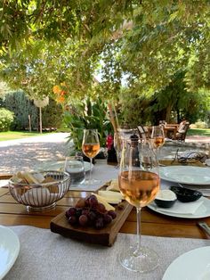 a wooden table topped with plates and glasses of wine