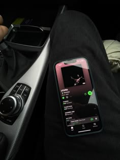 a cell phone sitting on top of a car dashboard next to a person's lap