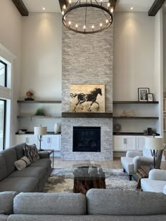 a living room with couches and a fire place in the center, along with a painting on the wall